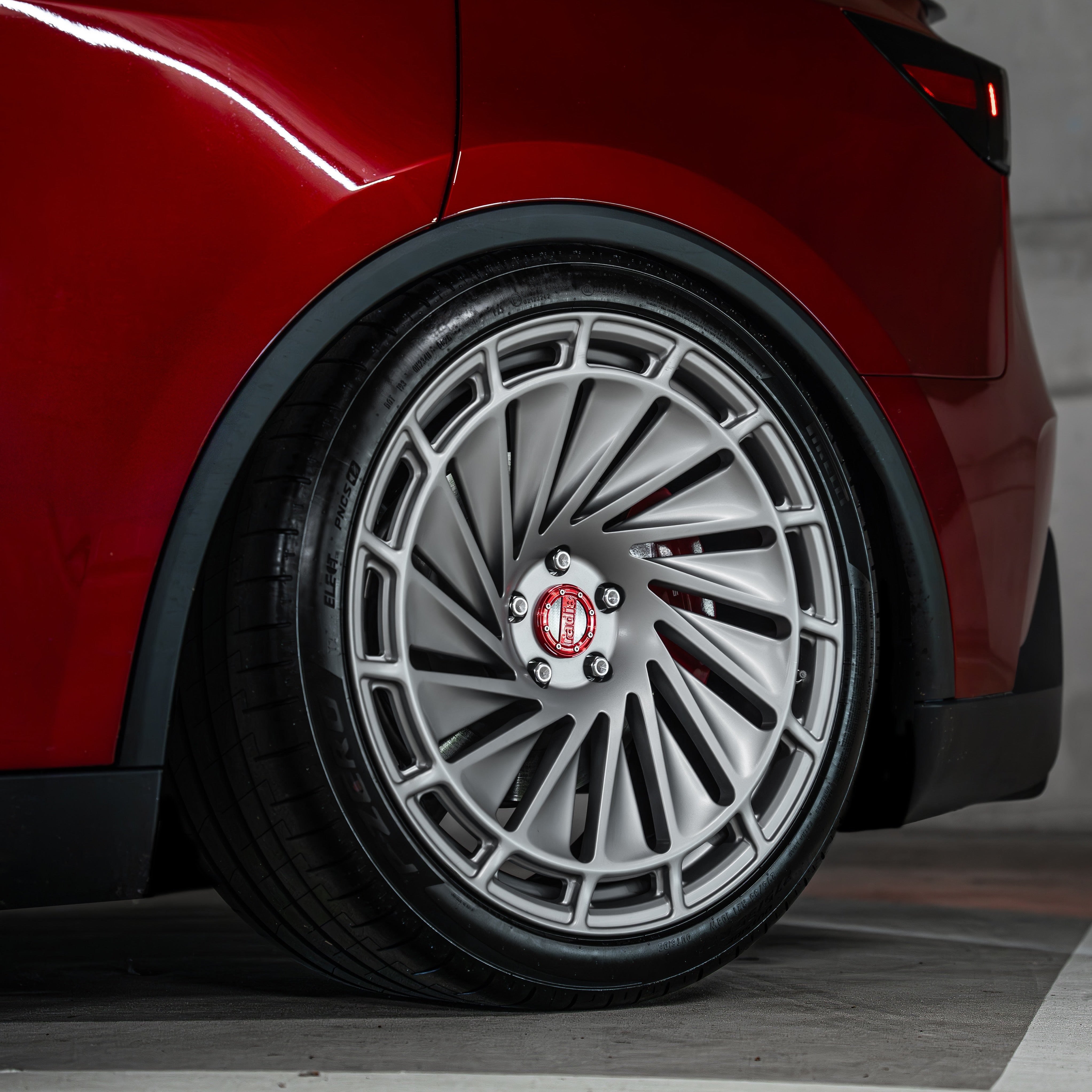 Rear view showing the wide tire fitment on 21x10,5J Radi8 R807 wheels on a Model Y. | Breite Felgen hinten